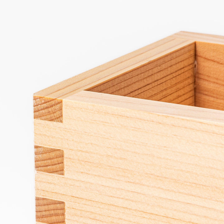 Traditional hinoki wood masu sake cup with visible joinery, offering a natural aroma and authentic way to enjoy Japanese sake or serve condiments.