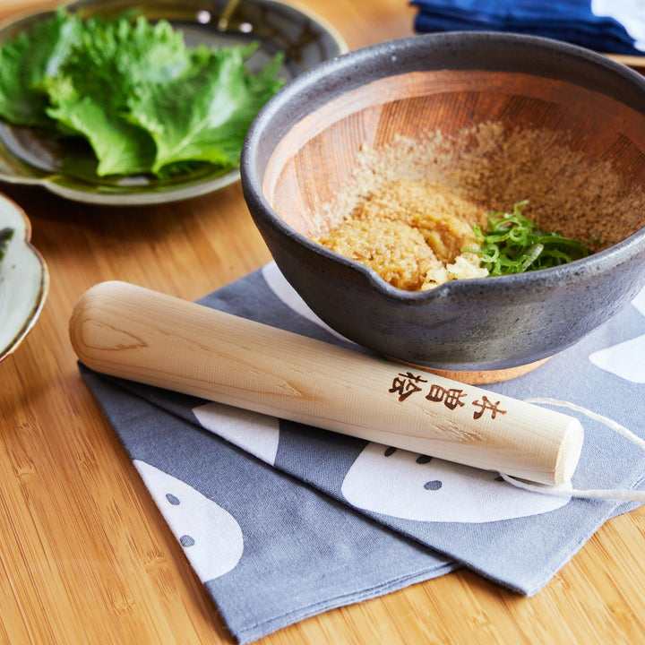 Smooth hinoki wood pestle engraved with Japanese characters, perfect for grinding in traditional Japanese cooking.