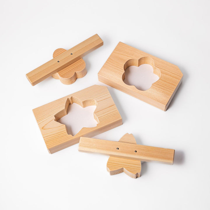 Set of Hinoki wood onigiri molds in plum blossom and sakura shapes, perfect for crafting decorative rice balls with a fragrant, traditional touch.