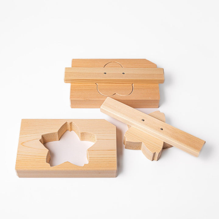 Set of Hinoki wood onigiri molds in plum blossom and sakura shapes, perfect for crafting decorative rice balls with a fragrant, traditional touch.