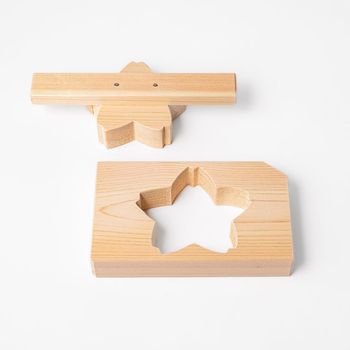 Hinoki wood onigiri mold in a sakura shape, designed for pressing rice into flower forms with a natural aroma and traditional Japanese charm.
