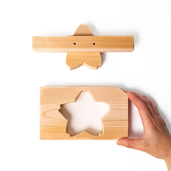 Hinoki wood onigiri mold in a sakura shape, designed for pressing rice into flower forms with a natural aroma and traditional Japanese charm.
