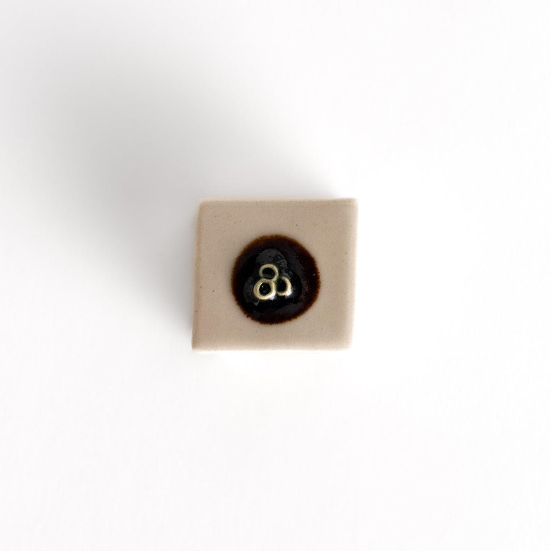 Chopstick rest shaped like a block of hiyayakko tofu, featuring a beige ceramic cube with a decorative circular detail for authenticity.