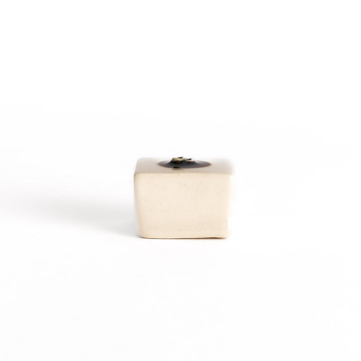Chopstick rest shaped like a block of hiyayakko tofu, featuring a beige ceramic cube with a decorative circular detail for authenticity.