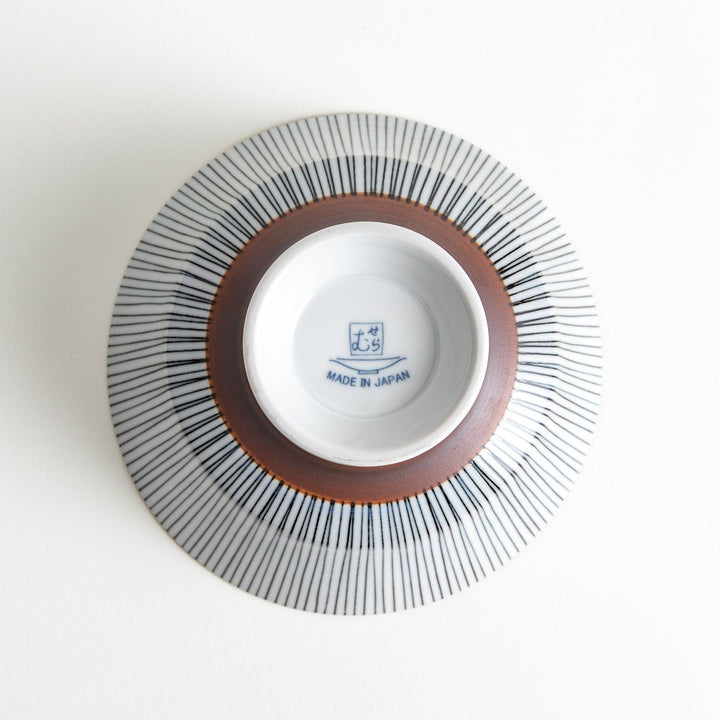 A white bowl with fine, vertical brown stripes and a brown rim, offering a sleek and modern design.