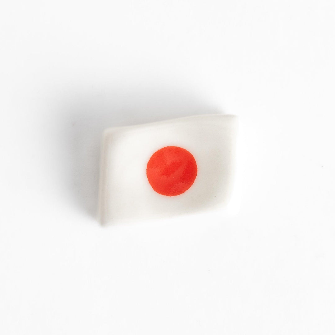 Chopstick rest shaped like the Japanese flag, with a red circle in the center, offering a minimalist and patriotic design.