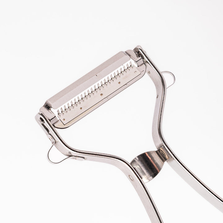 Japanese daikon julienne peeler with stainless steel blade and ergonomic looped handle for thin vegetable strips