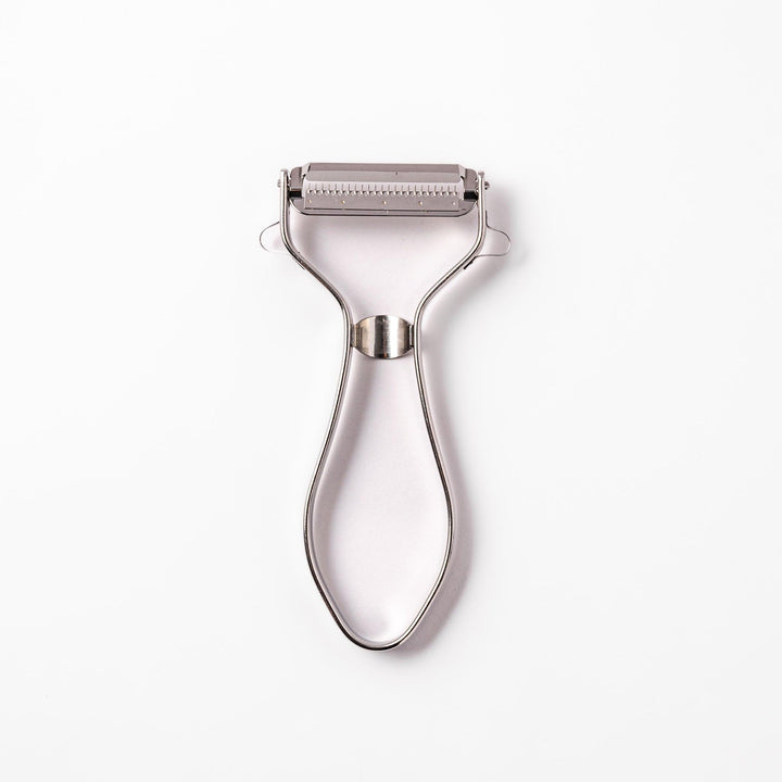 Japanese daikon julienne peeler with stainless steel blade and ergonomic looped handle for thin vegetable strips