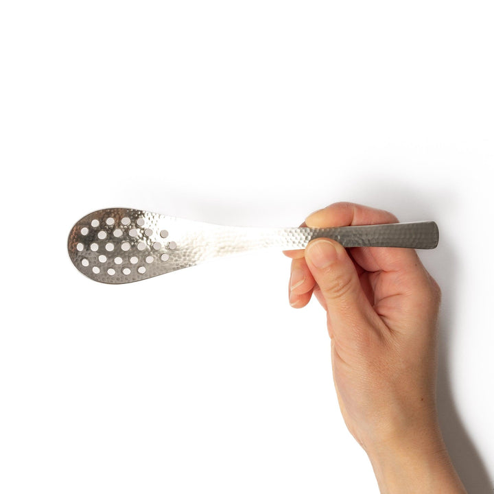 Handcrafted Japanese hammered straining spoon with perforated bowl, ideal for skimming or serving foods while draining excess liquid.