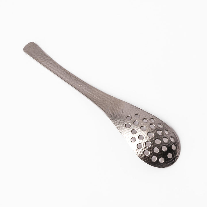 Handcrafted Japanese hammered straining spoon with perforated bowl, ideal for skimming or serving foods while draining excess liquid.