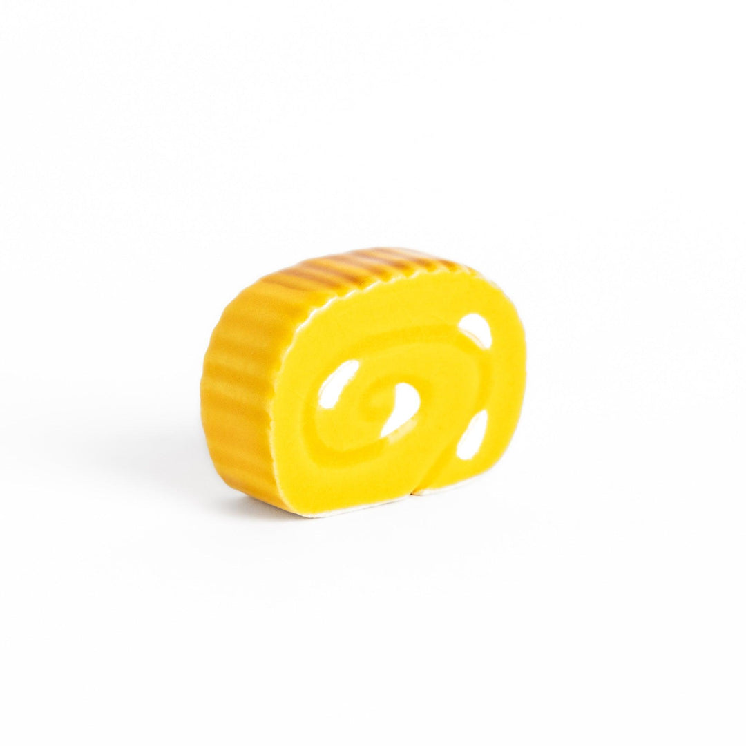 Chopstick rest shaped like a Japanese rolled omelette, featuring vibrant yellow details for a fun and authentic dining experience.