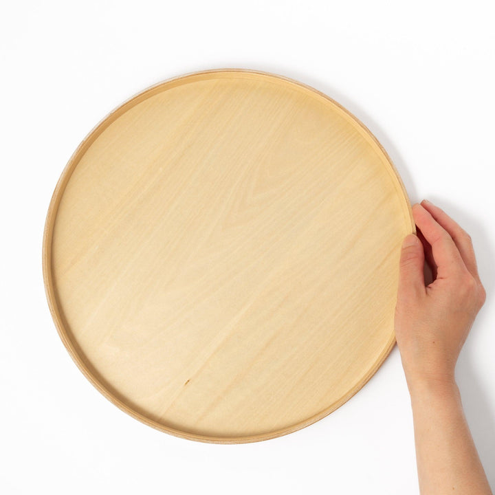 Minimalist Japanese round wooden tray with raised edge, crafted from natural wood, perfect for serving tea, snacks, or organizing small items.
