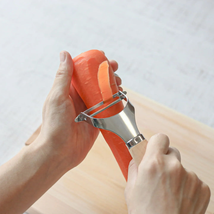 Japanese Wood Handle Peeler, a functional kitchenware with a stainless steel blade and ergonomic wooden handle, ideal for effortless vegetable peeling.