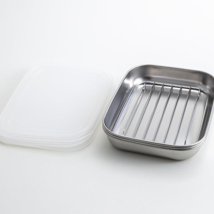 Rectangular stainless steel food prep trays with a wire rack and a white plastic lid.