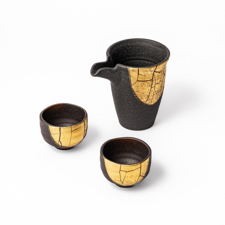Kintsugi-inspired black and gold Kutani sake set with one spouted carafe and two cups, blending traditional Japanese art with modern elegance.