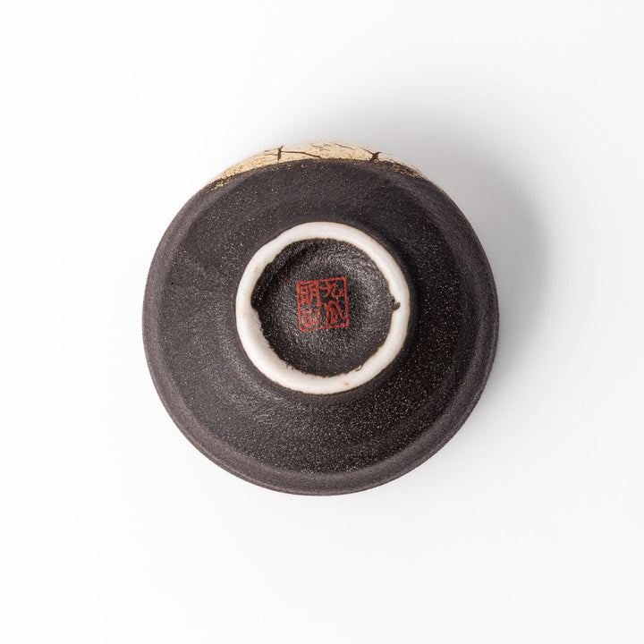 Kintsugi-inspired black Kutani sake cup with bold gold crack design, blending traditional Japanese craftsmanship with contemporary elegance.