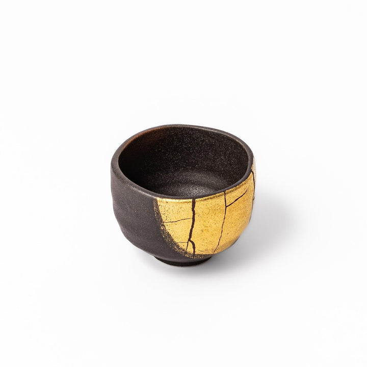 Kintsugi-inspired black Kutani sake cup with bold gold crack design, blending traditional Japanese craftsmanship with contemporary elegance.