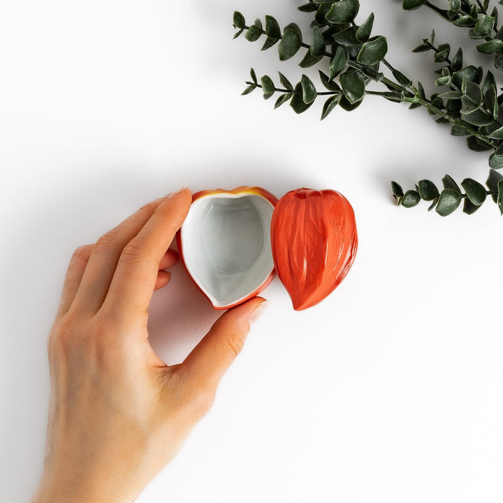 Unique Lantern Plant lidded condiment bowl shaped like a vibrant orange lantern fruit, with intricate details and a smooth, glossy finish, ideal for adding charm to your table setting.