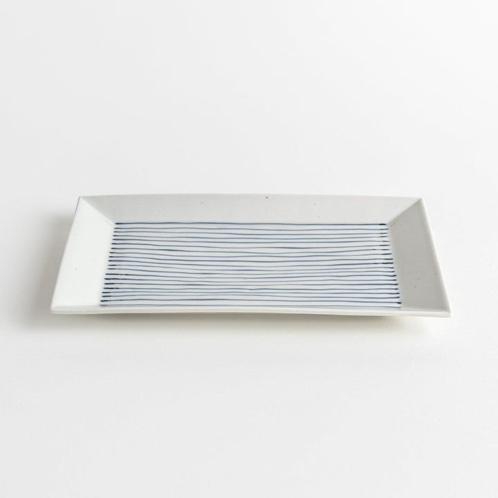 A rectangular ceramic plate with blue horizontal stripes, simple and elegant design.