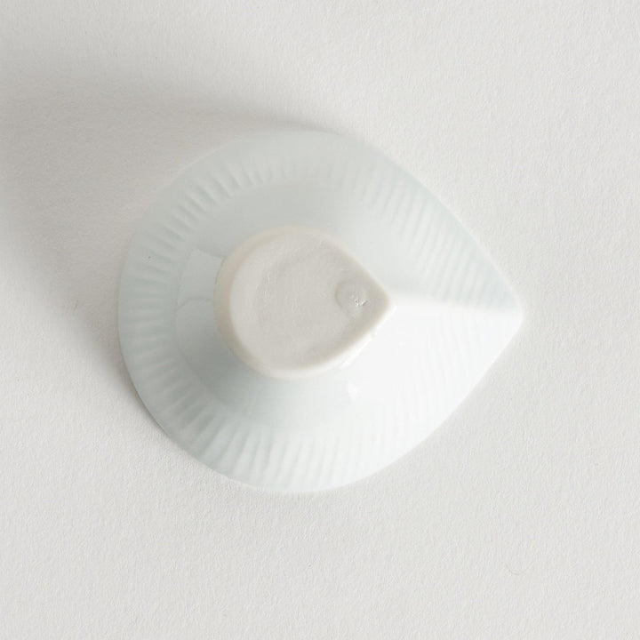 A small white condiment dish with a subtle ribbed pattern.