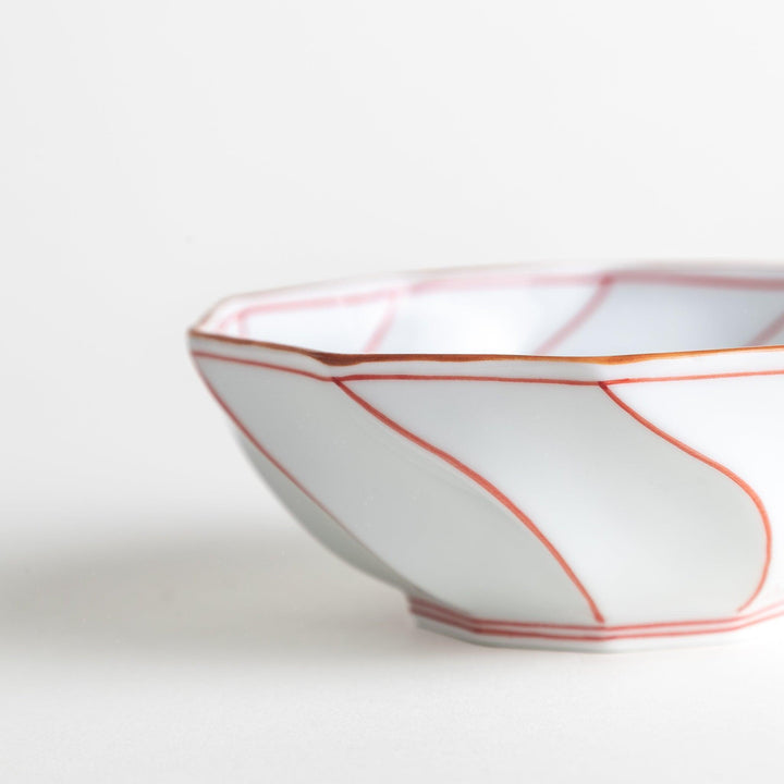 Deep white octagonal dessert bowl with a petal design, outlined in blue or red and finished with a brown rim.