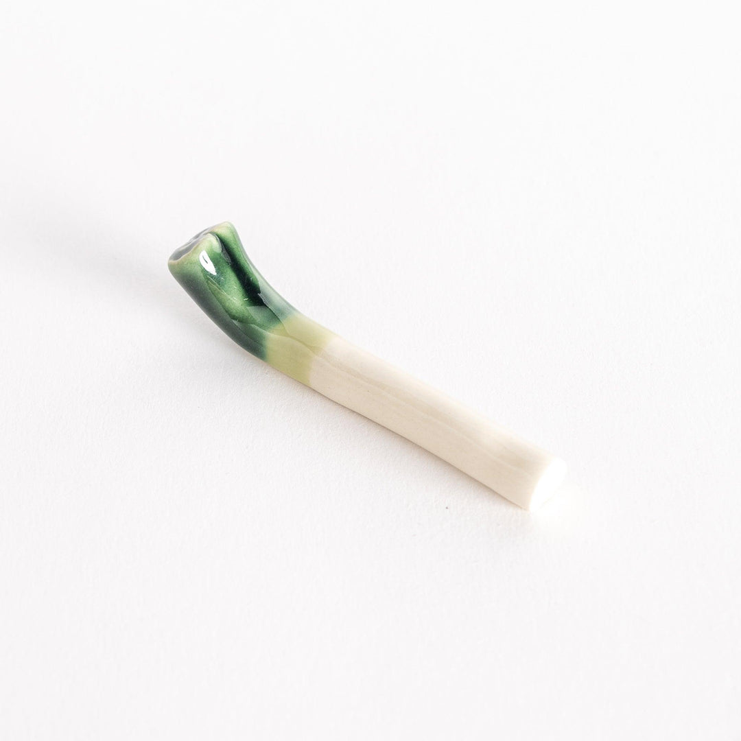 Slightly angled view of the glossy green onion chopsticks rest, showcasing its smooth ceramic finish.