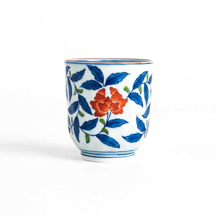 Elegant porcelain teacup with vibrant blue and orange floral design and green leaves, showcasing fine craftsmanship and vivid colors.