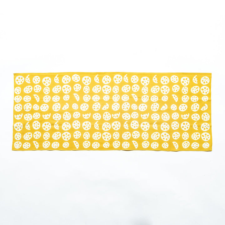Yellow hand towel showcasing white lotus root slice patterns, fully spread.
