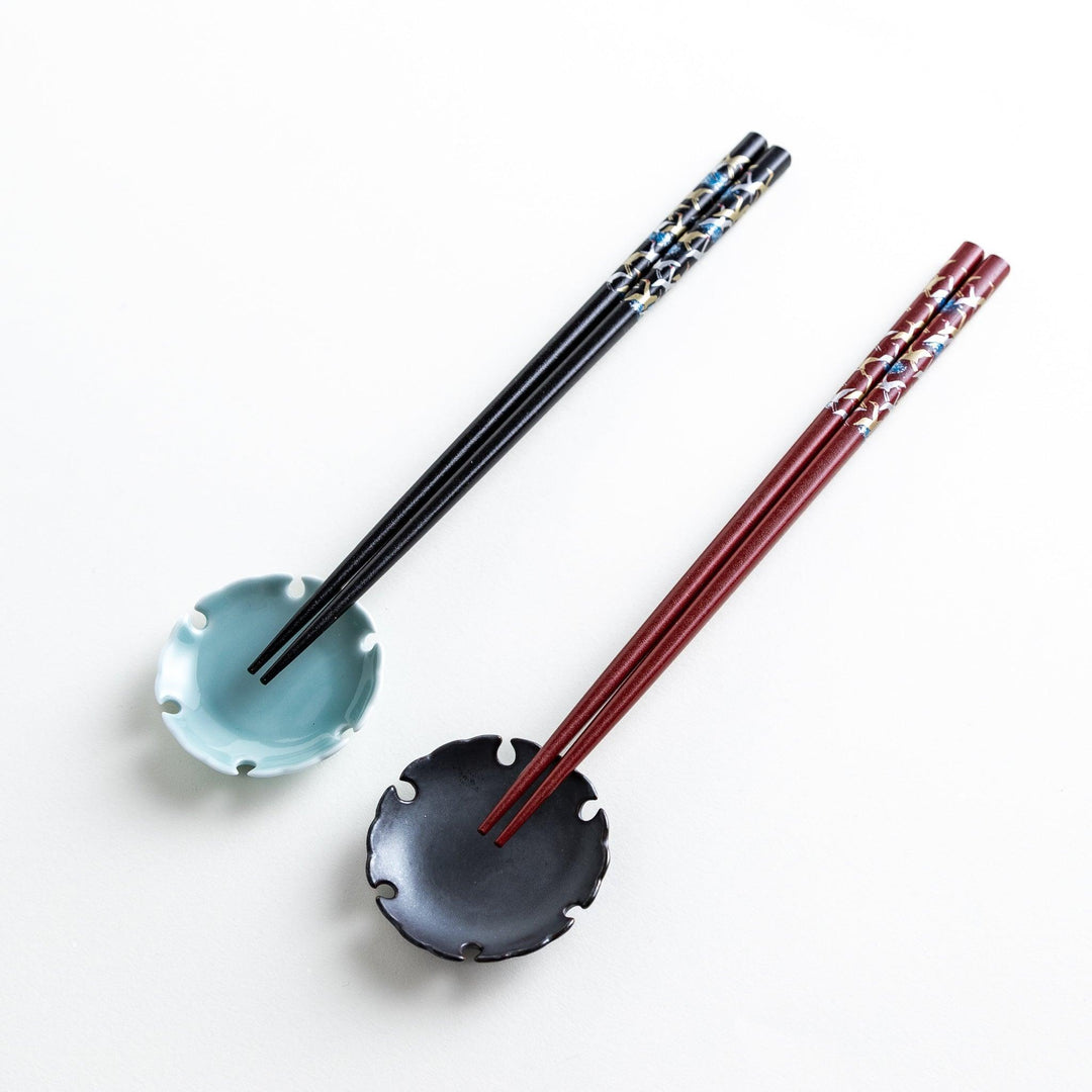 A boxed set of two pairs of chopsticks, one with a black and one with crane patterns on the handles.
