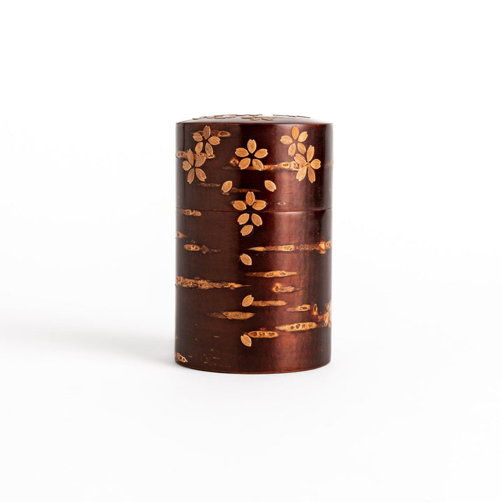 Traditional Japanese tea canister crafted from cherry bark with a delicate cherry blossom design, perfect for storing and preserving tea leaves.