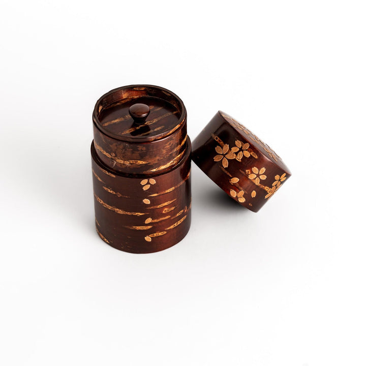 Traditional Japanese tea canister crafted from cherry bark with a delicate cherry blossom design, perfect for storing and preserving tea leaves.