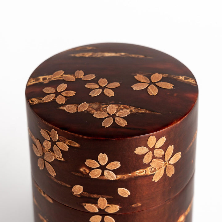 Traditional Japanese tea canister crafted from cherry bark with a delicate cherry blossom design, perfect for storing and preserving tea leaves.