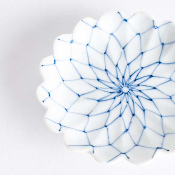 White sauce dish with a blue chrysanthemum mesh pattern and scalloped edges.
