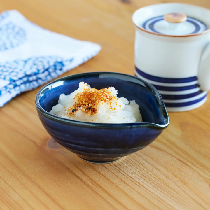 Japanese indigo blue ceramic bowl filled with grated daikon radish topped with seasoning, perfect for traditional tableware.