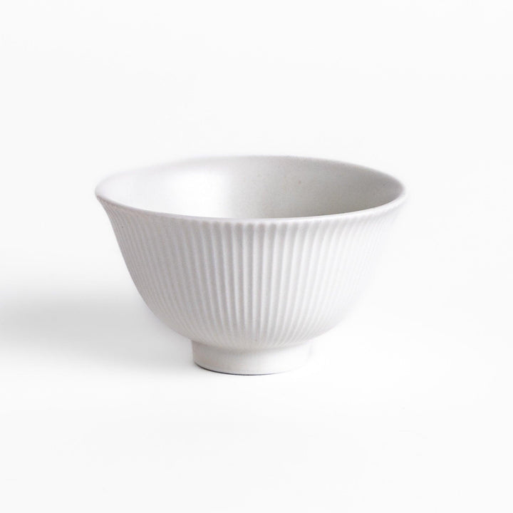 Minimalist ribbed white teacup with a gently flared rim and a smooth base, offering a simple yet elegant design perfect for everyday tea rituals.