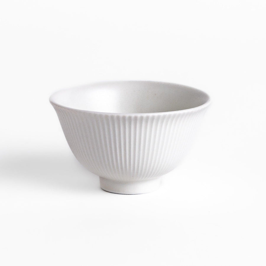 Minimalist ribbed white teacup with a gently flared rim and a smooth base, offering a simple yet elegant design perfect for everyday tea rituals.