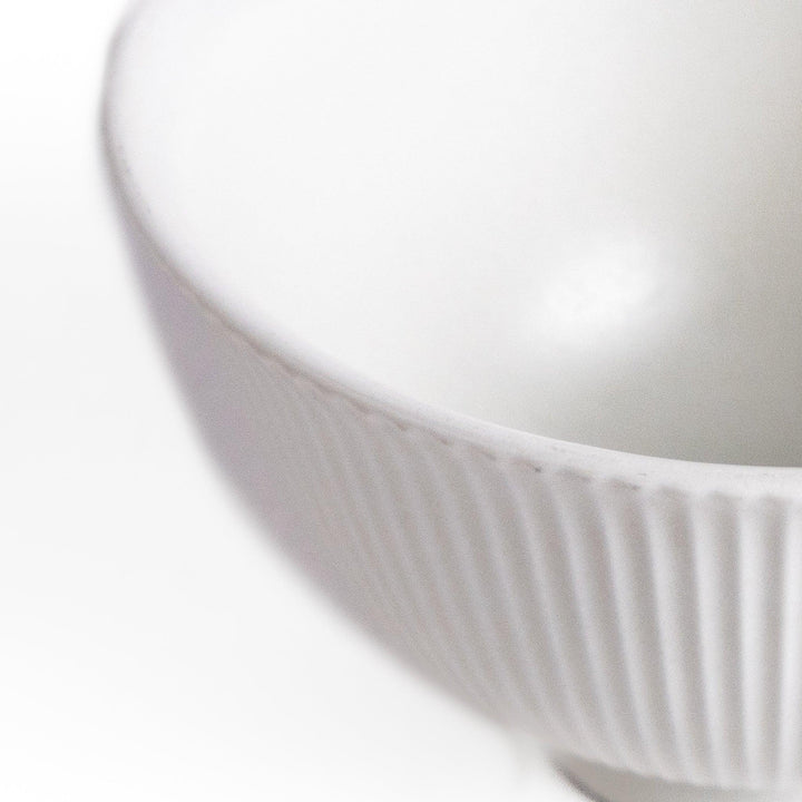 Minimalist ribbed white teacup with a gently flared rim and a smooth base, offering a simple yet elegant design perfect for everyday tea rituals.