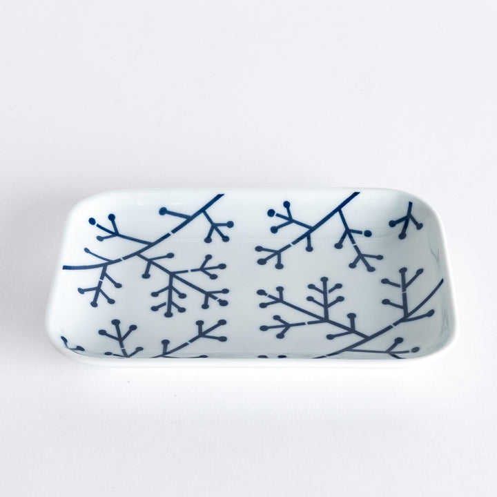 Slightly angled view of a dessert plate highlighting the indigo pine branch pattern with intricate geometric details.