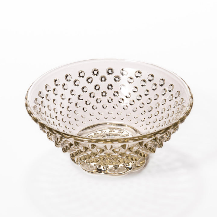 Amber-toned glass dessert bowl and saucer set with raised dot pattern and starburst base, ideal for refined sweets or fruit servings.