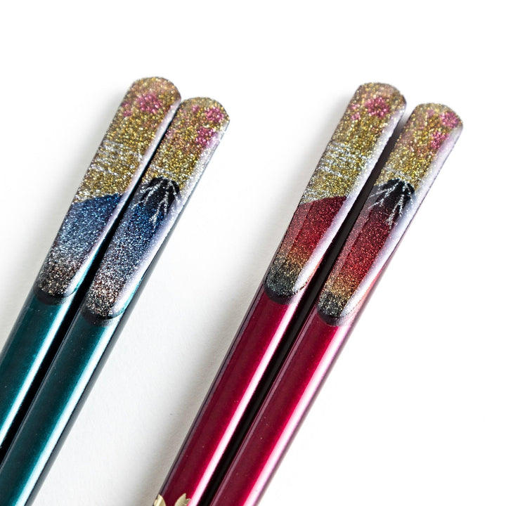 A boxed set of two pairs of chopsticks, one with blue and one with red handles, featuring Mount Fuji designs.