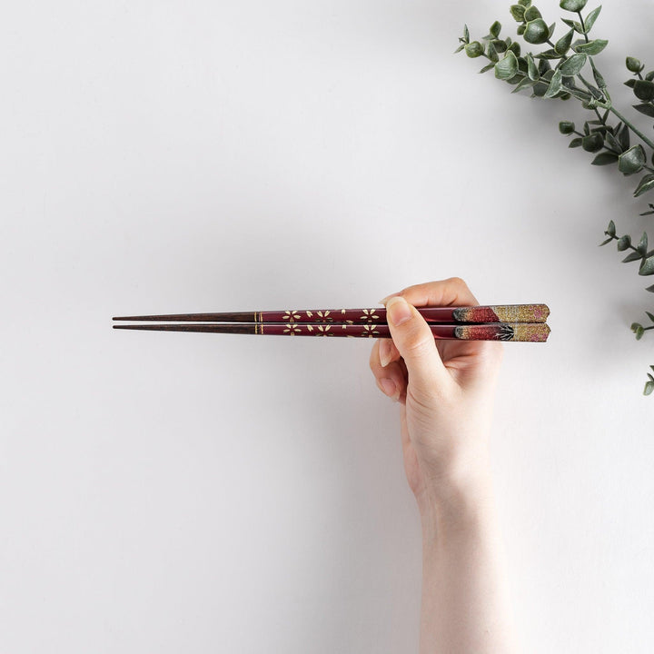 A boxed set of two pairs of chopsticks, one with blue and one with red handles, featuring Mount Fuji designs.