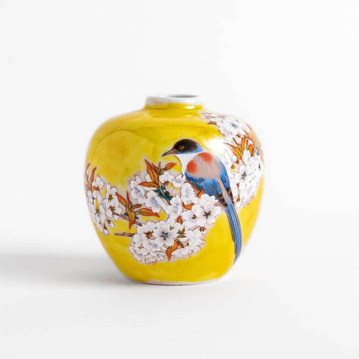Bright yellow vase adorned with delicate cherry blossoms and a colorful bird, capturing the essence of spring in a beautifully painted design.