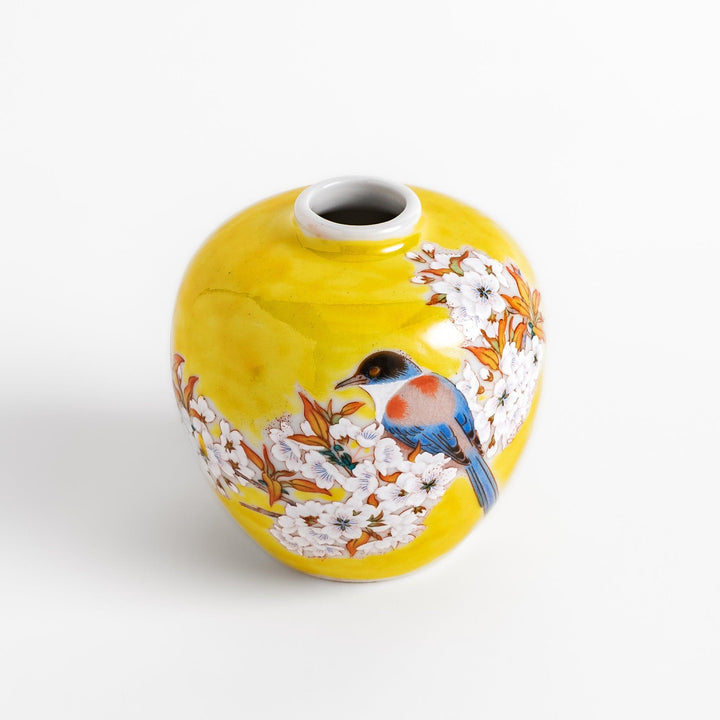 Bright yellow vase adorned with delicate cherry blossoms and a colorful bird, capturing the essence of spring in a beautifully painted design.