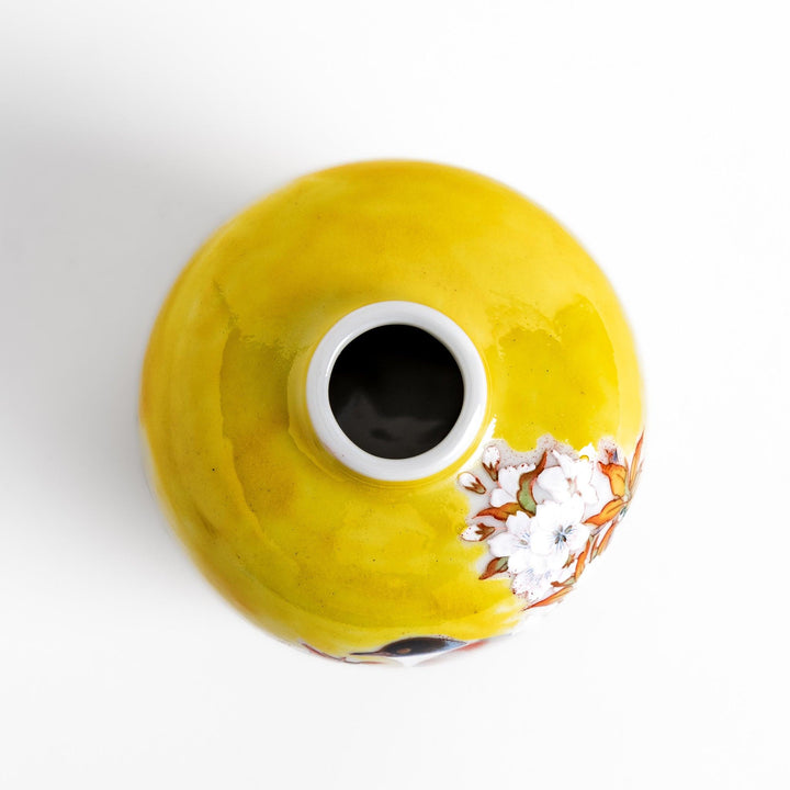Bright yellow vase adorned with delicate cherry blossoms and a colorful bird, capturing the essence of spring in a beautifully painted design.