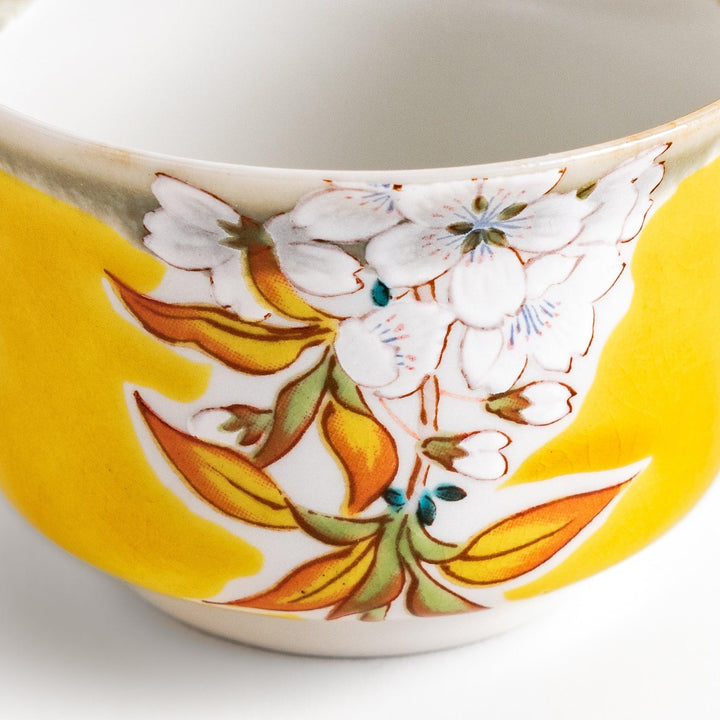 Yellow sake cup with a delicate cherry blossom design, perfectly complementing spring-themed tableware for a vibrant and charming dining experience.