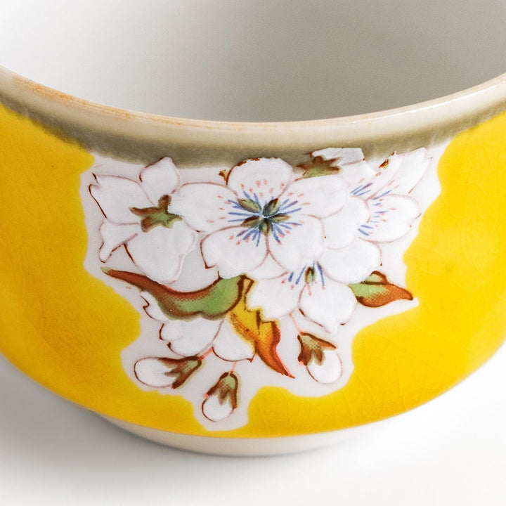 Yellow sake cup with a delicate cherry blossom design, perfectly complementing spring-themed tableware for a vibrant and charming dining experience.