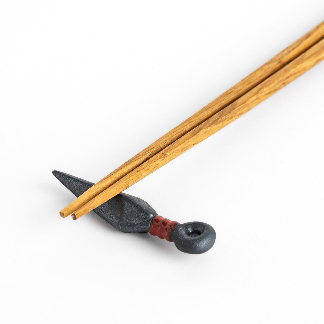 Sleek ninja blade-shaped chopstick rest with a metallic finish and red accent, adding a bold and unique touch to your dining experience.