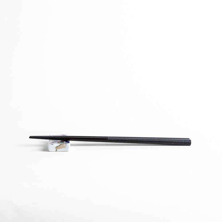 Octagonal wooden chopsticks with a brown tone, finished with a textured grain. Available in red or black.