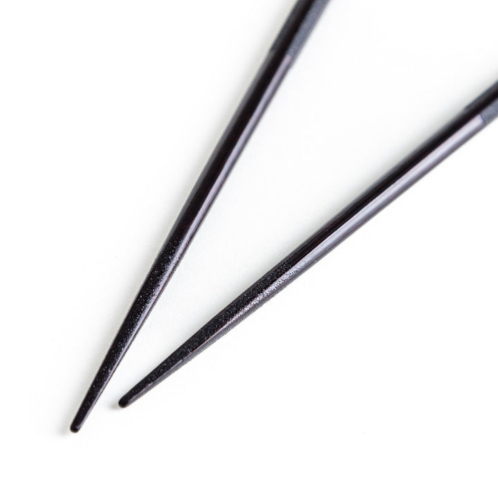 Octagonal wooden chopsticks with a brown tone, finished with a textured grain. Available in red or black.