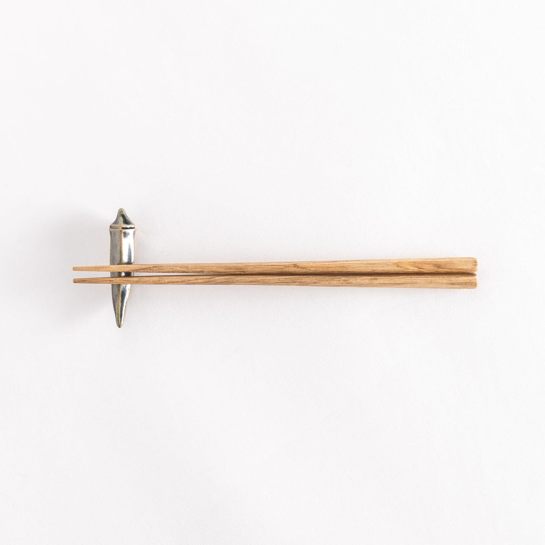 Full view of chopsticks placed on the okra-shaped rest.